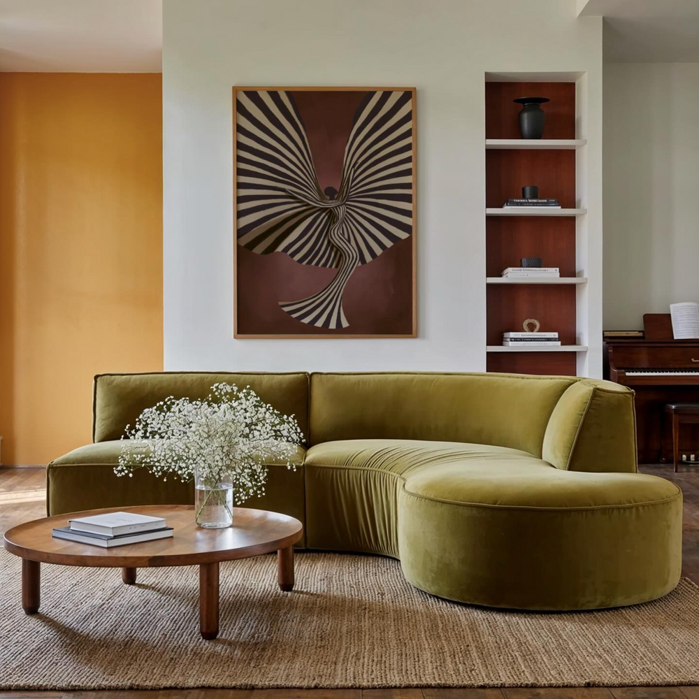 Modern living room featuring an olive green curved sofa, round wooden coffee table with flowers, abstract black and beige wall art, and built-in shelving with decor items, highlighting premium wall art prints.